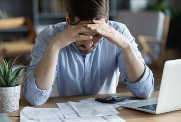 Hombre estresado contemplando embargo de nomina