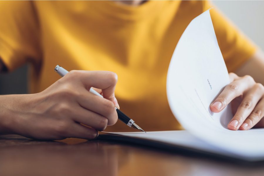 Mujer firmando un contrato de prestamo con capital privado