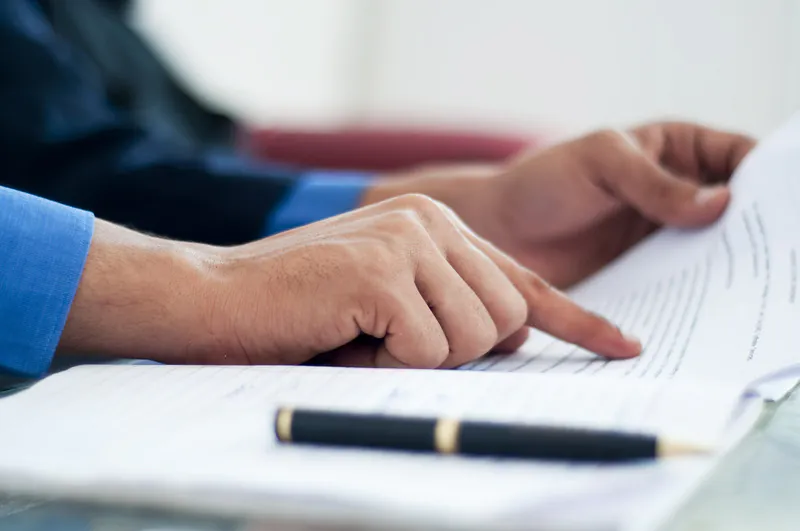 Primer plano de alguien consultando un documento hipotecario