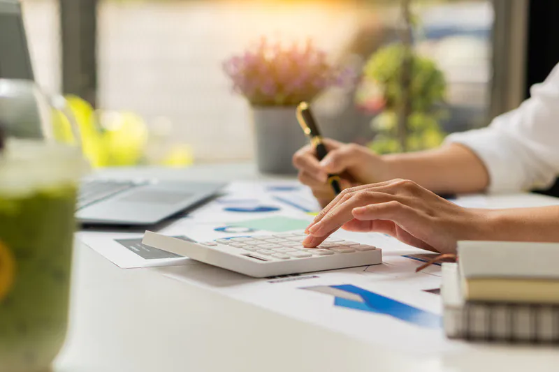 Persona que utiliza una calculadora para comprobar sus cuentas financieras para recibir un préstamo de capital privado solo con nomina