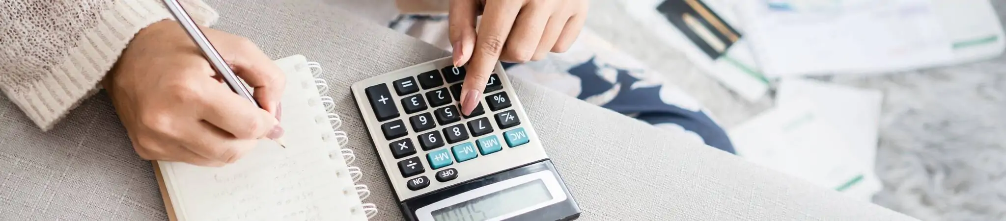 Mujer joven calculando cuanto ahorrar con un préstamo para reunificar deudas